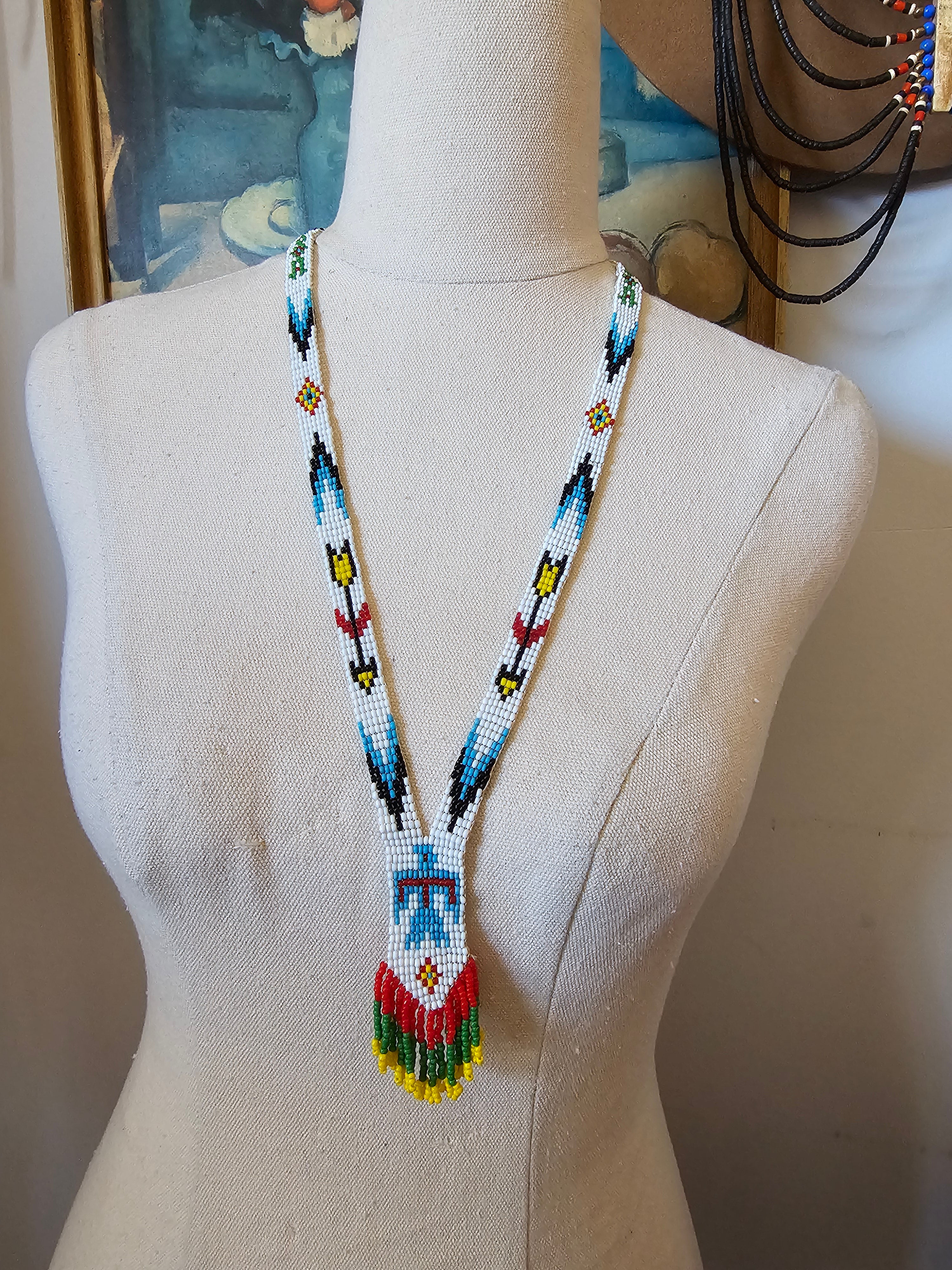 Mannequin head with a colorful beaded headband on a neutral background
