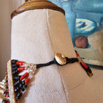 Decorative object with beads and a button on a textured surface