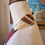 Textile with beadwork on a mannequin against a blurred background