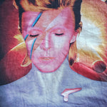 Close-up of a David Bowie 'Aladdin Sane' graphic t-shirt featuring the album cover art and title text on a dark background.