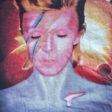 Close-up of a David Bowie 'Aladdin Sane' graphic t-shirt featuring the album cover art and title text on a dark background.