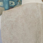 Close-up of a person wearing beige pants and white shoes with a blurred background