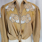 Beige fabric with floral embroidery on a mannequin against a white background