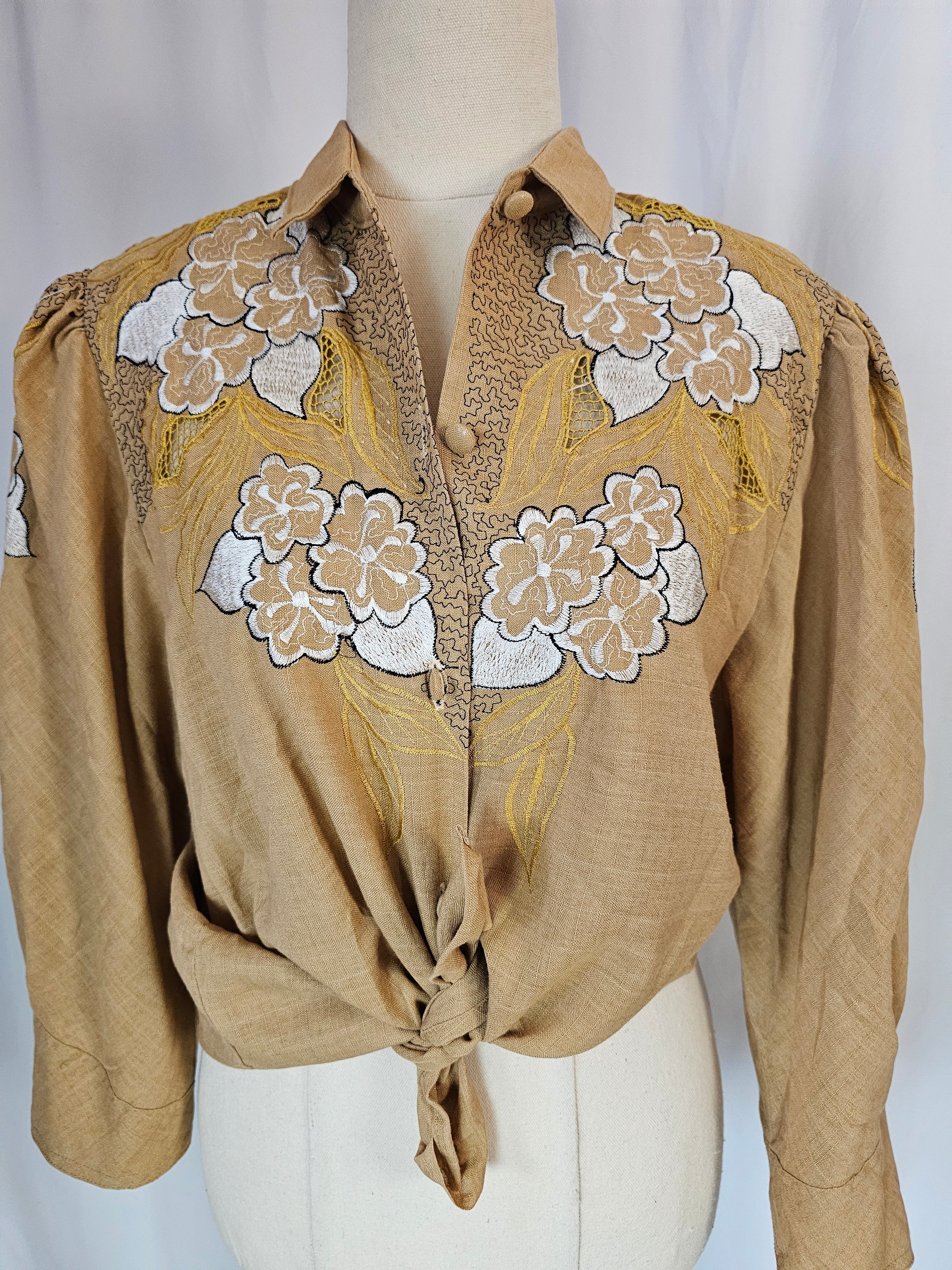 Beige fabric with floral embroidery on a mannequin against a white background