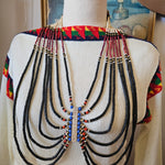 Traditional beaded necklace on a mannequin with a colorful background