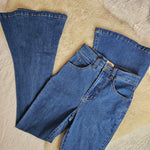 Pair of blue jeans on a textured beige surface