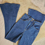 Pair of blue jeans on a textured beige surface