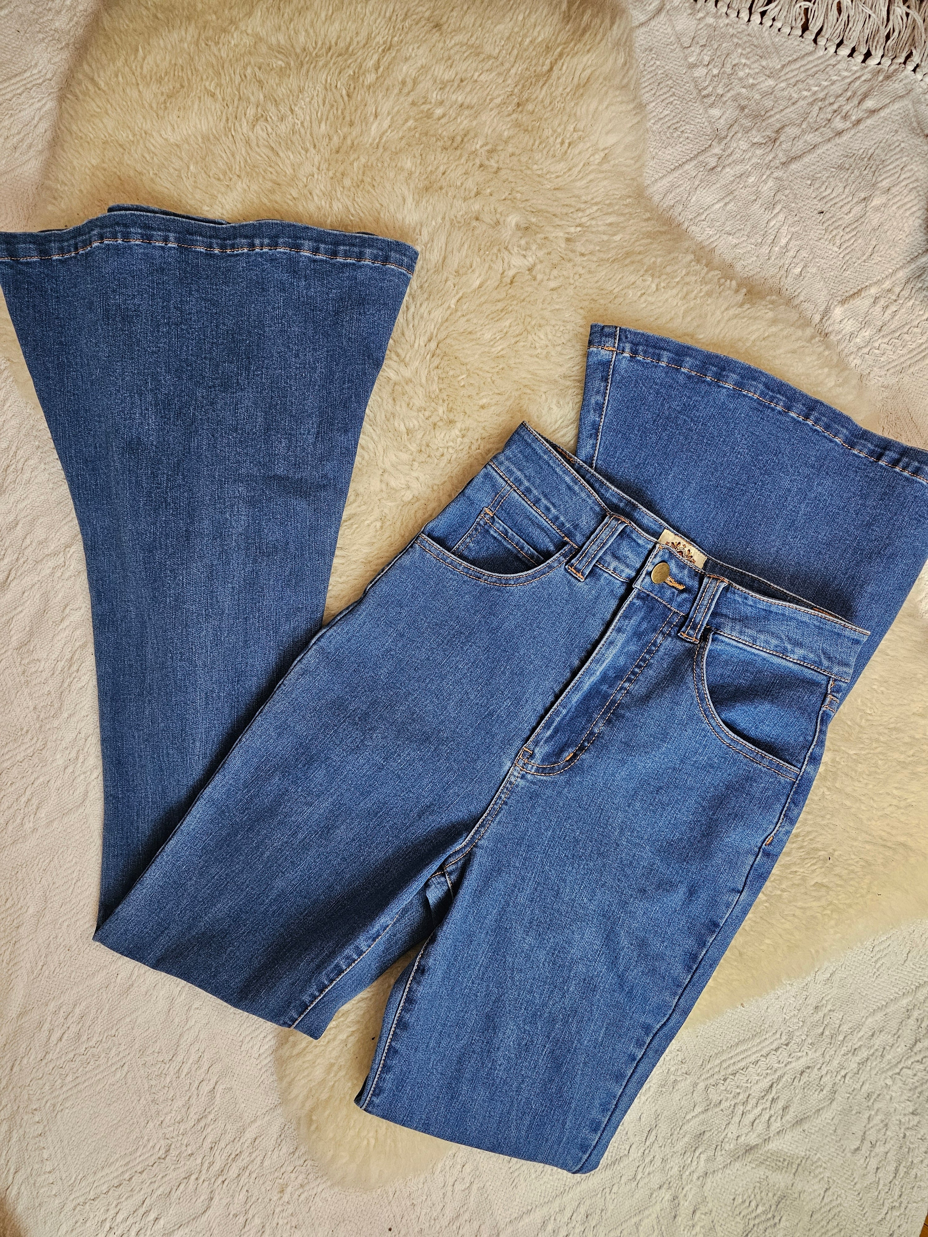 Pair of blue jeans on a textured beige surface