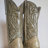 Pair of leather boot-shaped ottomans with intricate designs on a white background.