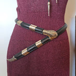 Maroon glove with decorative black and gold strap on a white background