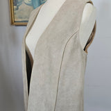 Mannequin wearing a beige coat with a plain background