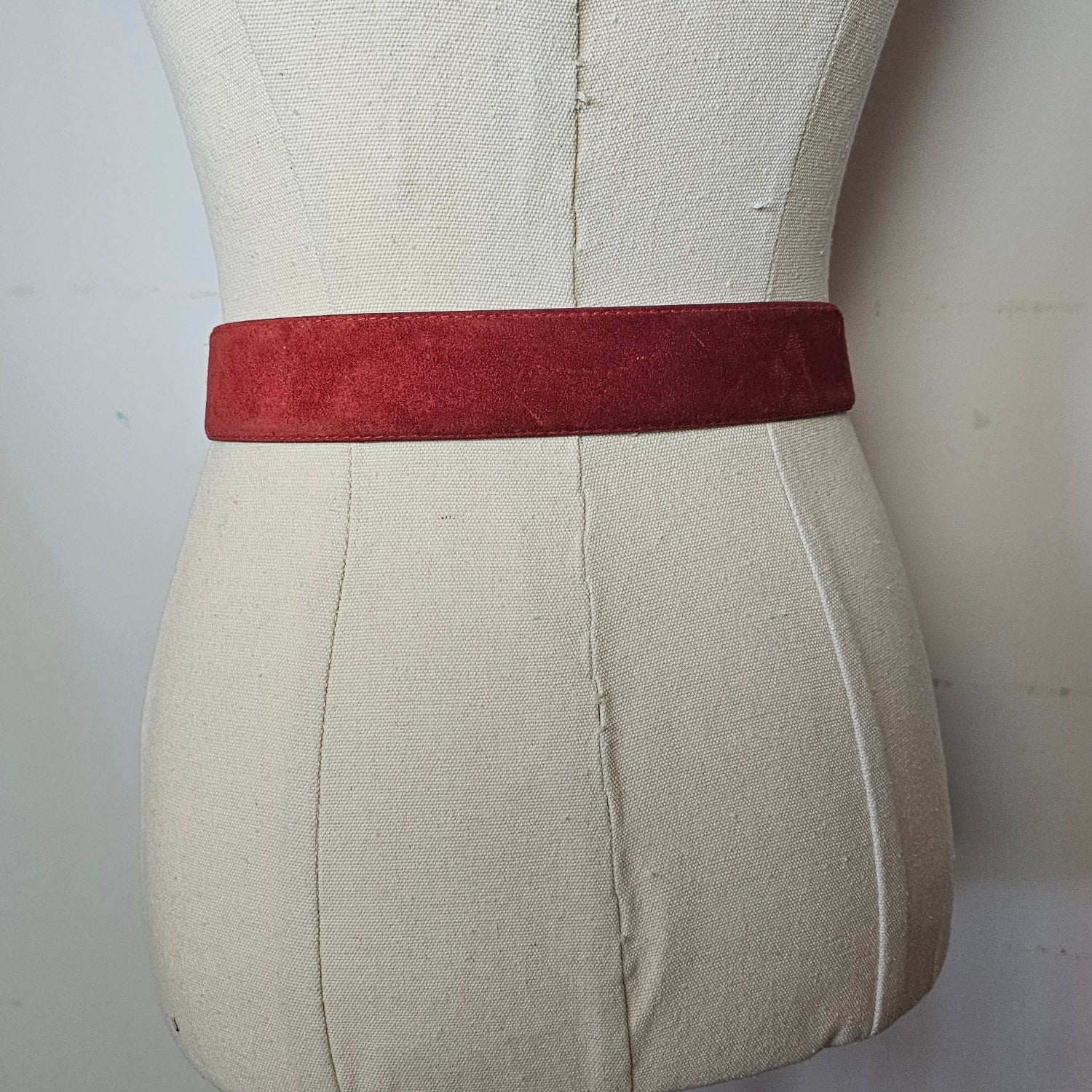 Close-up of a beige cushion with a red band on a white background