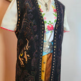 Decorative black leather belt with intricate patterns on a neutral background