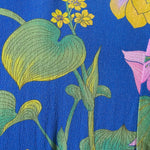 Floral fabric pattern with yellow, green, and pink flowers on a blue background