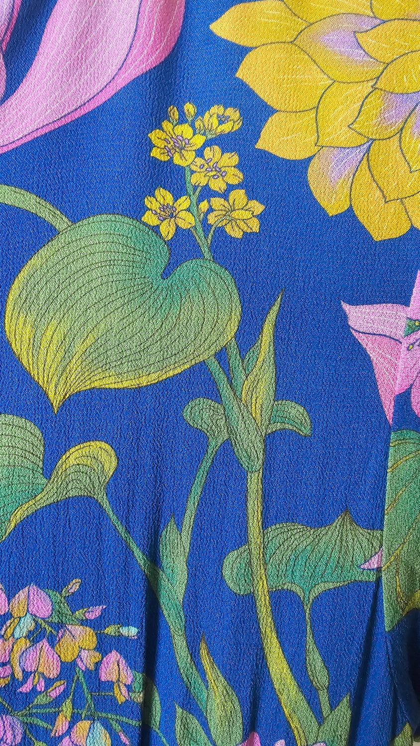 Floral fabric pattern with yellow, green, and pink flowers on a blue background