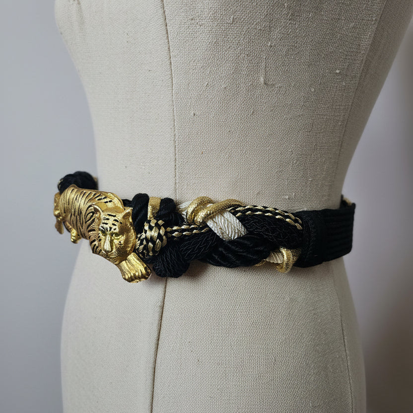 Black and gold braided belt on a mannequin with a plain background