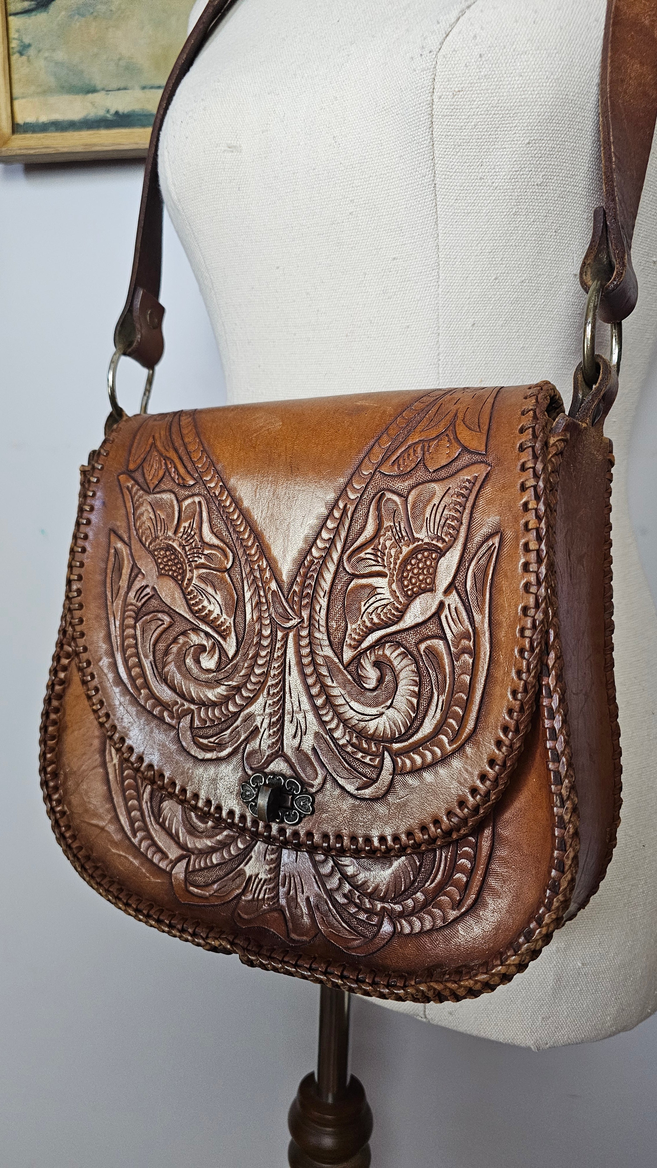 Brown leather wallet with intricate embossed designs on a white background