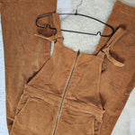 Brown overalls on a hanger against a white background