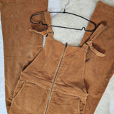 Brown overalls on a hanger against a white background