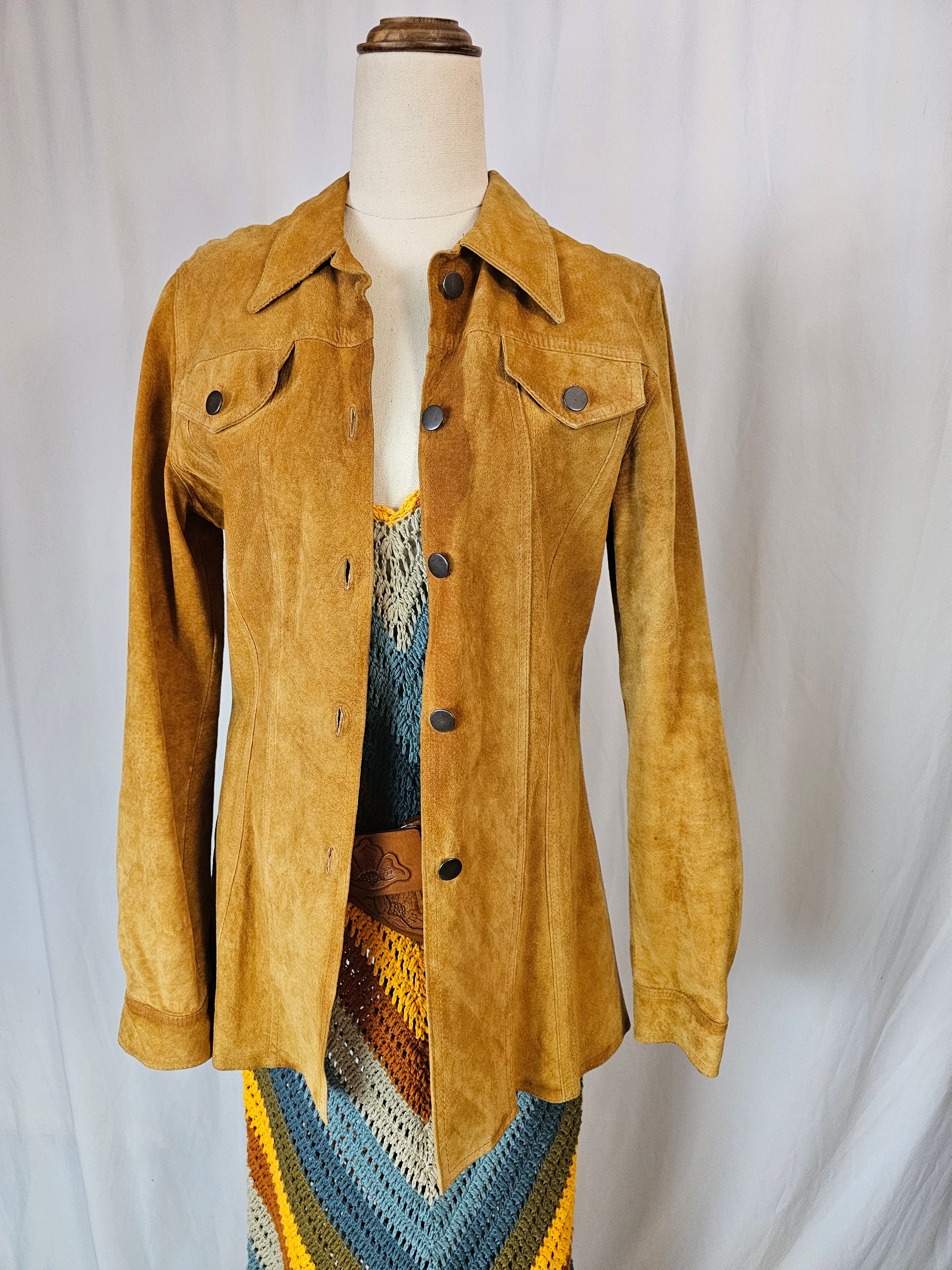 Brown jacket on a mannequin with a colorful patterned fabric background
