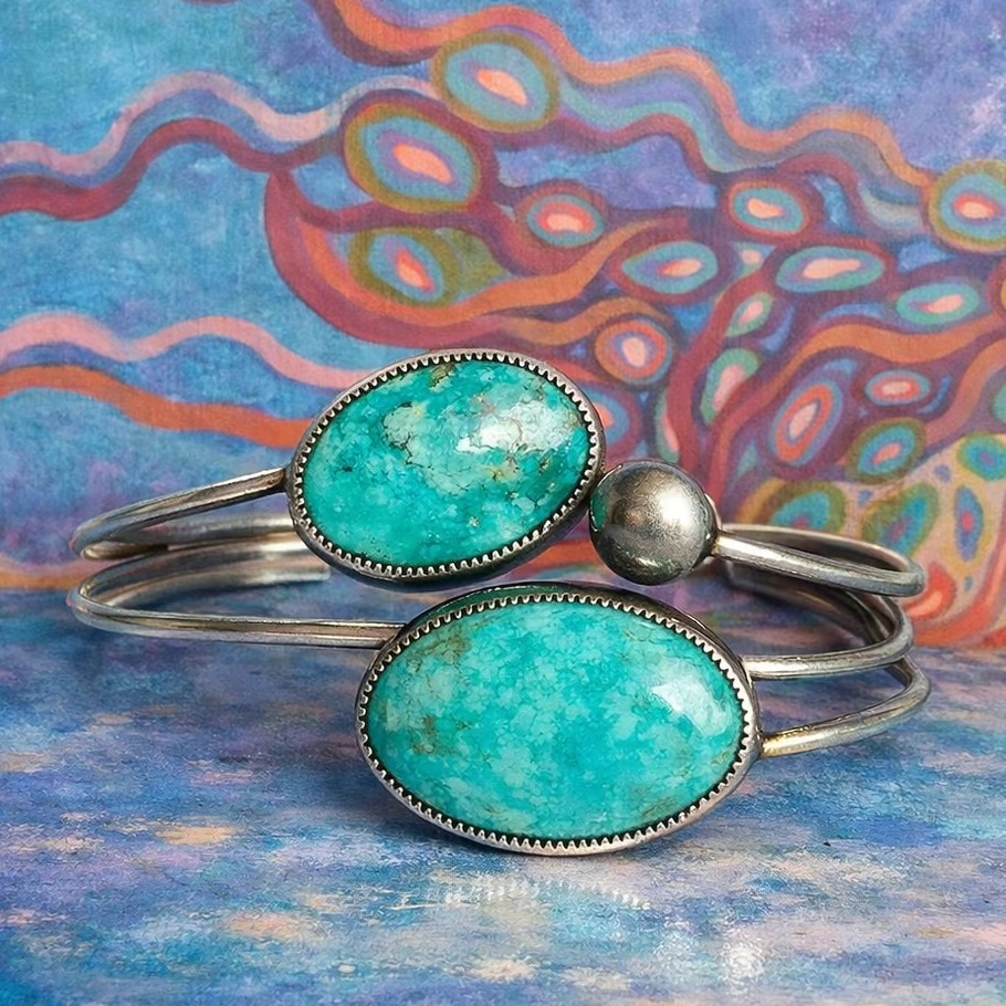 Turquoise cuffs on a colorful abstract background with text overlay