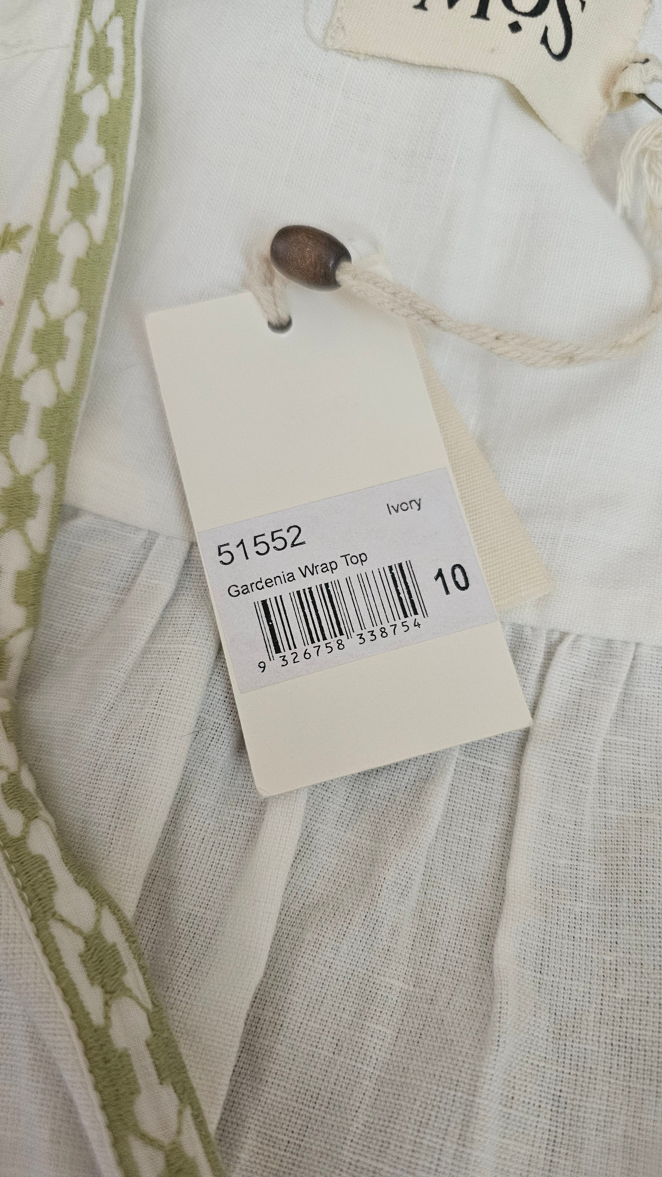 Close-up of a clothing tag with a barcode on a fabric background