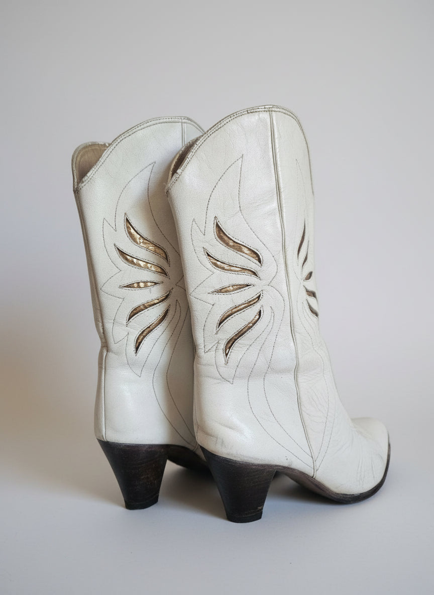 White leather glove with decorative stitching on a plain background