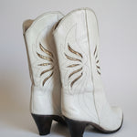 White leather glove with decorative stitching on a plain background