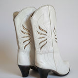 White leather glove with decorative stitching on a plain background