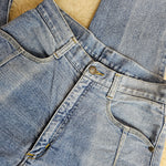 Close-up of blue denim jeans on a beige surface
