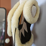 Pair of black shoes with white fuzzy bands on a blurred background