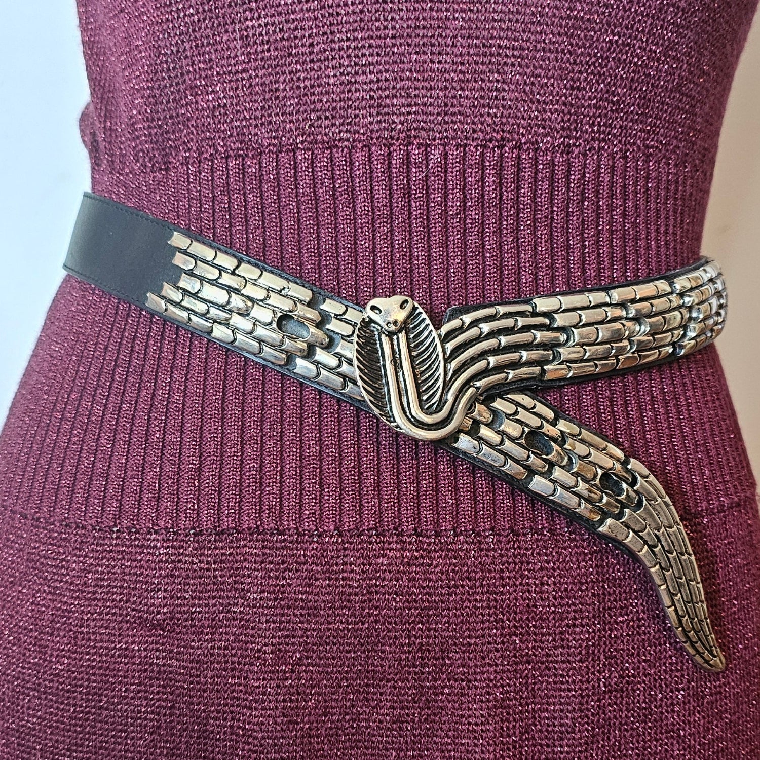 Close-up of a purple sweater with a decorative metal clasp.