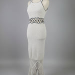 Mannequin wearing a white knitted garment with black patterns on a plain background