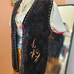 Decorative headband with intricate patterns and a floral fabric layer, worn by a person.