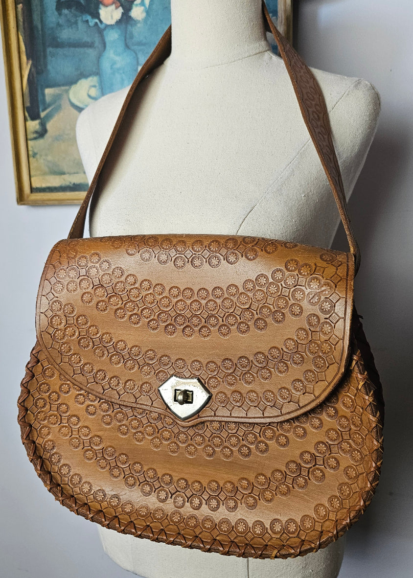 Close-up of a brown leather saddle pad on a horse with a blurred background
