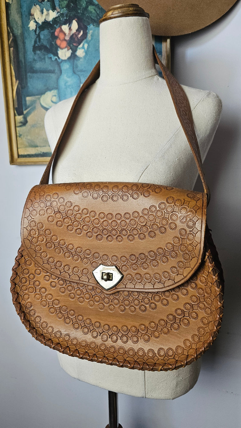 Close-up of a brown leather saddle pad on a horse with a blurred background