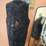 Black embroidered mask with intricate designs on a blurred background