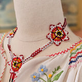 Embroidered garment with floral patterns on a mannequin