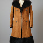 Brown coat with black fur trim on a mannequin against a neutral background