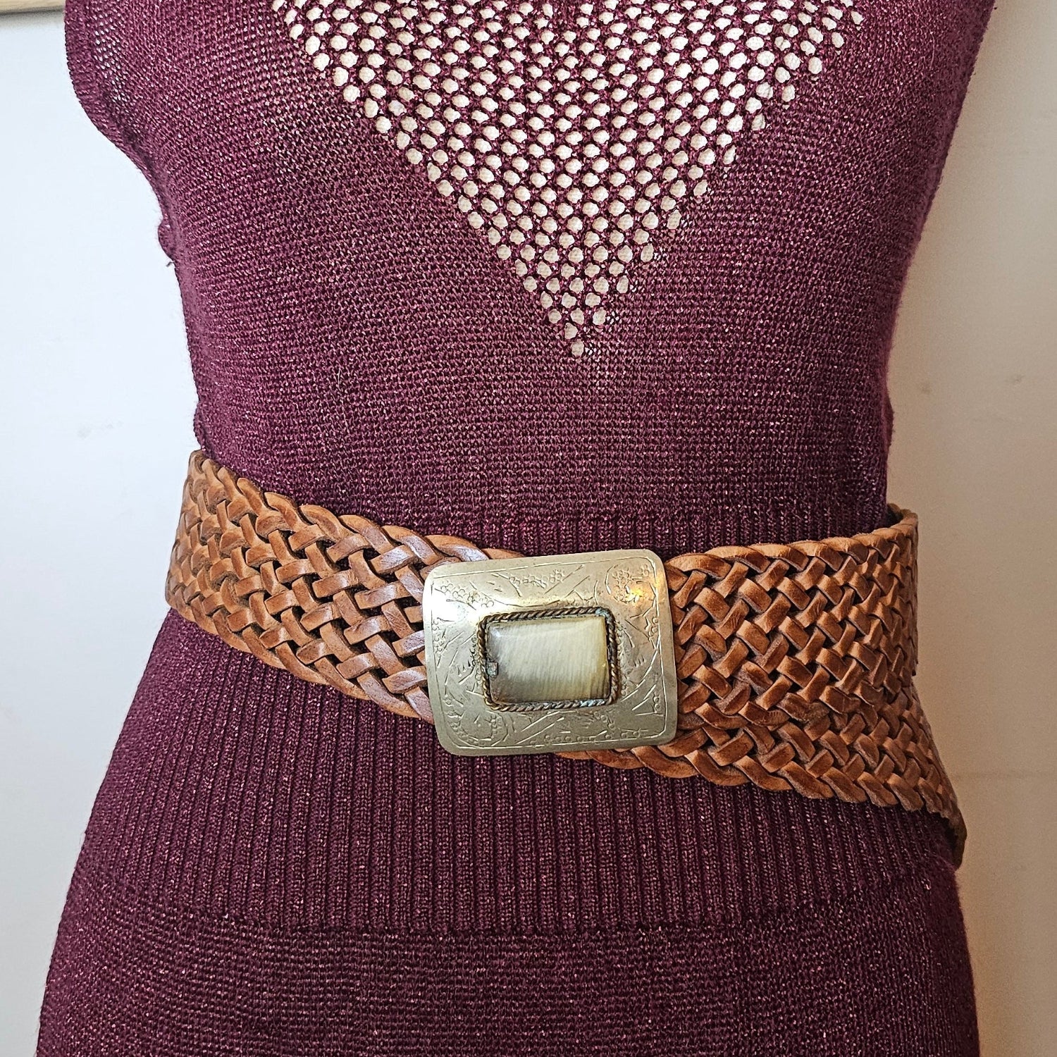 Maroon sweater with a brown belt and metal buckle on a white background