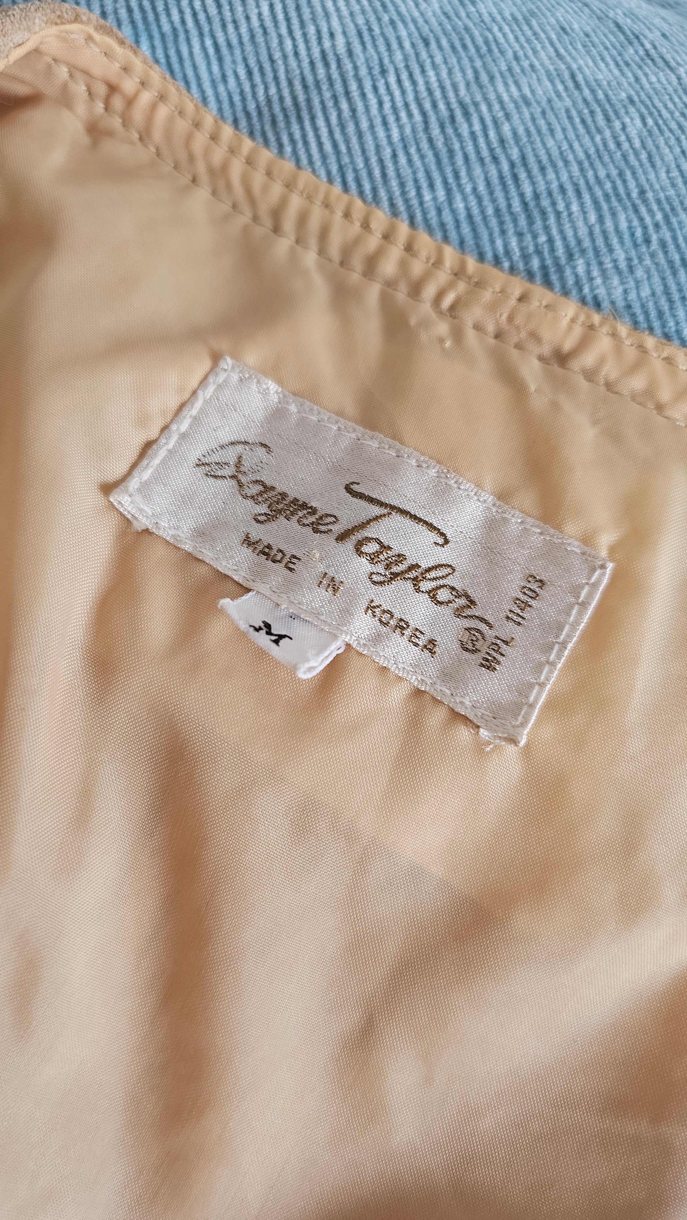 Close-up of a beige fabric with a brand label on a blurred background