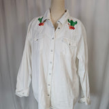 White shirt with embroidery on a mannequin against a plain background