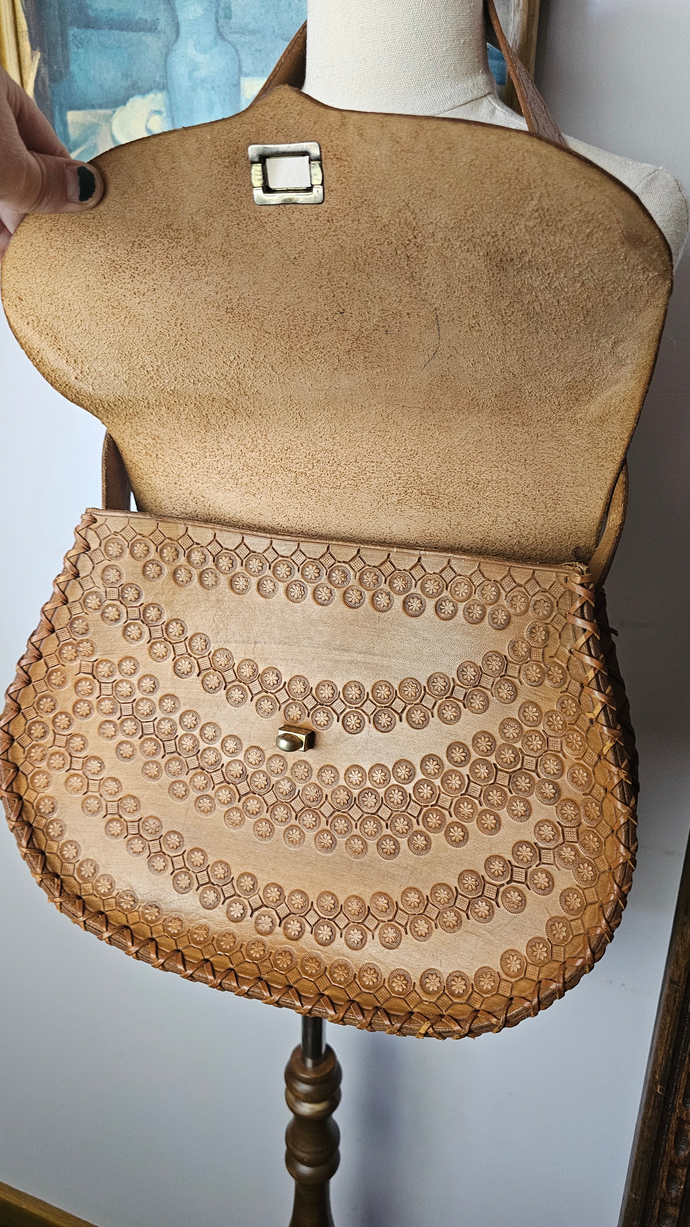 Close-up of a beige handbag with a textured pattern on a blurred background