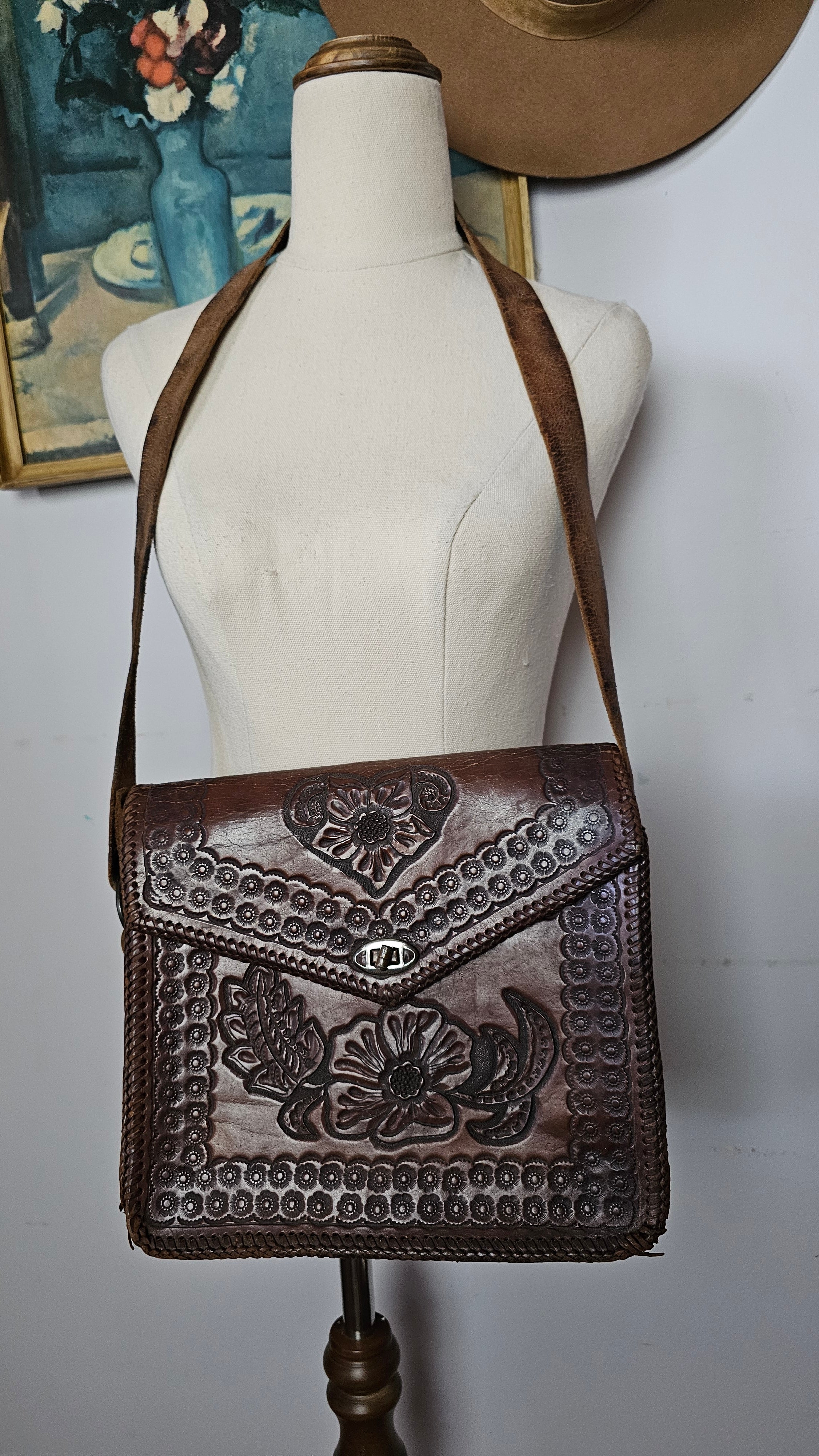 Brown leather handbag with intricate patterns on a white surface