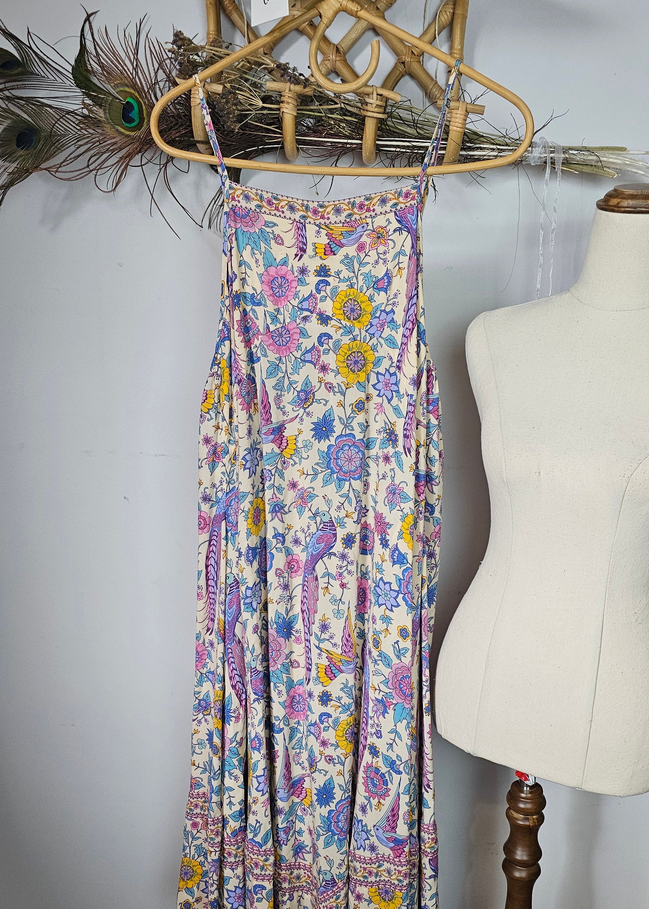 Floral-patterned belt on a mannequin against a white wall with decorative elements.
