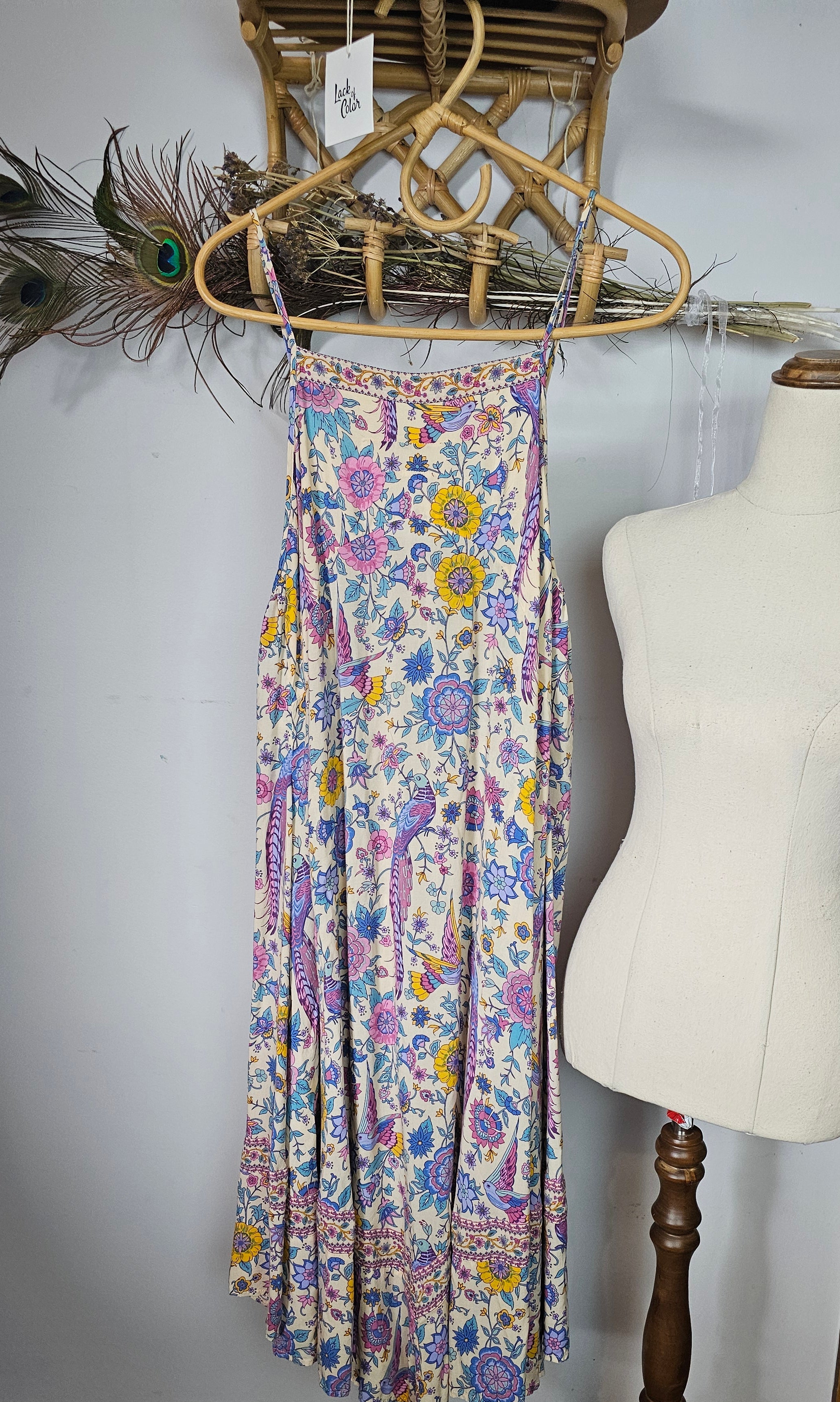 Floral-patterned belt on a mannequin against a white wall with decorative elements.