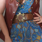 Person wearing a brown leather vest over a blue patterned dress with a gold belt.