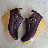 Pair of brown wedge shoes with wooden soles on a white fur surface