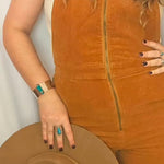 Person wearing a brown suede jacket with a plain background