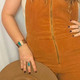 Person wearing a brown suede jacket with a plain background